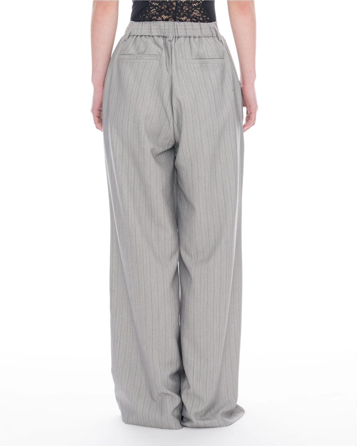 A person shown from the back wearing light gray wide-leg pinstripe trousers with an elastic waistband and back pockets, against a plain white studio background.
