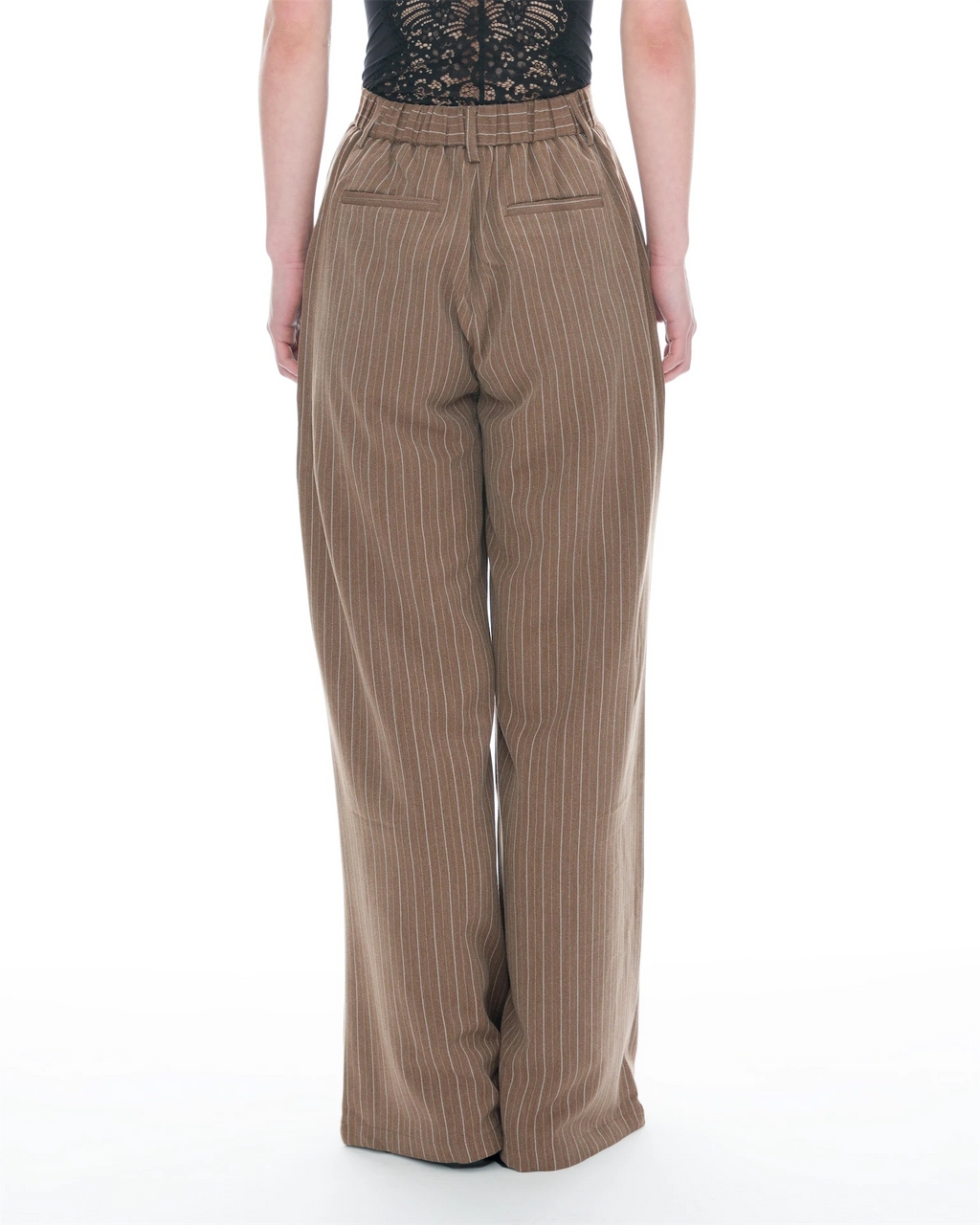 A person shown from the back wearing high-waisted, wide-leg trousers in a warm taupe-brown with thin vertical pinstripes, paired with a black lace top, against a plain white studio background.