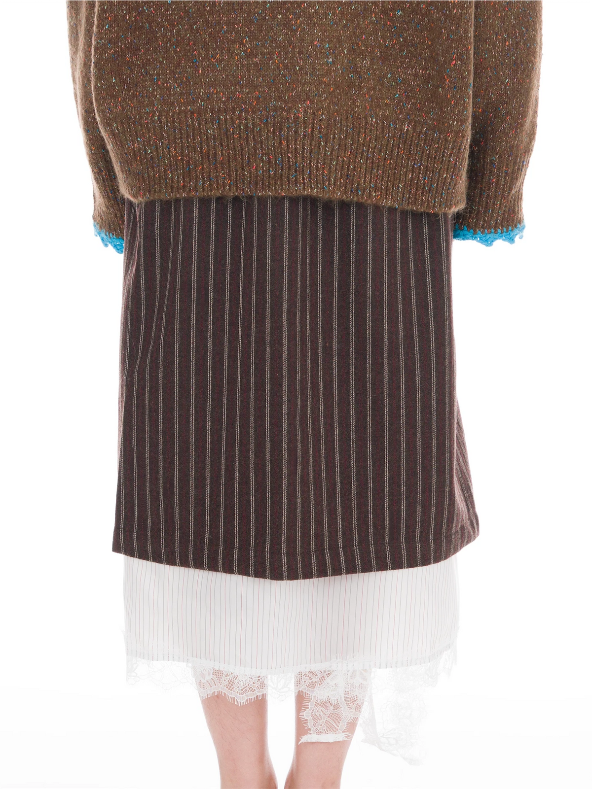 A person shown from the back wearing a brown knit sweater with blue trim, a dark brown pinstriped skirt, and a white pleated skirt with lace hem.