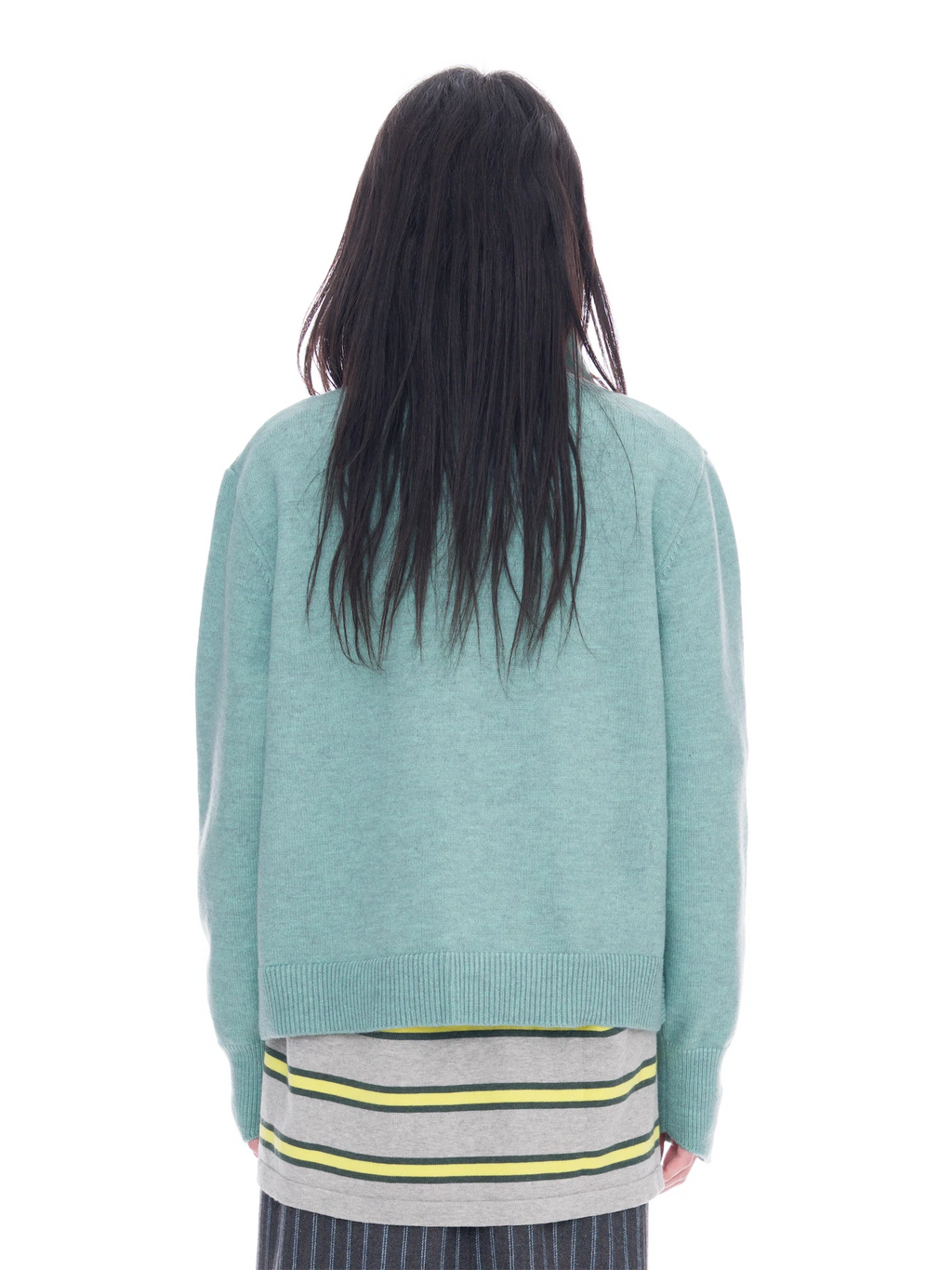 A person viewed from the back wearing a light mint green knit sweater over a gray striped shirt with yellow and green stripes, against a plain white background.