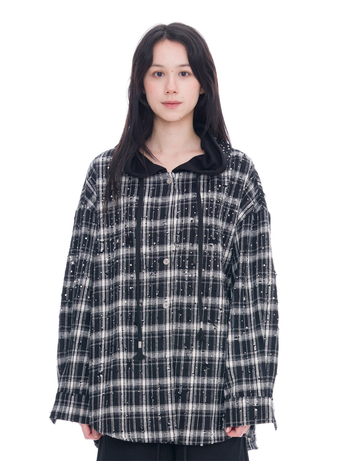 A model wearing an oversized black and white plaid button-up shirt with a black collar, photographed against a solid white background.