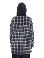 A person shown from the back wearing a black and white plaid hooded shirt with distressed details and a black hood, photographed against a plain white background.